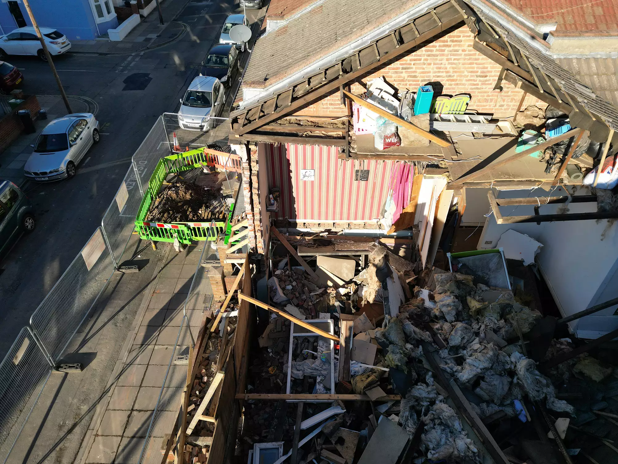 Aerial view of a damaged building with exposed roof structure and scaffolding